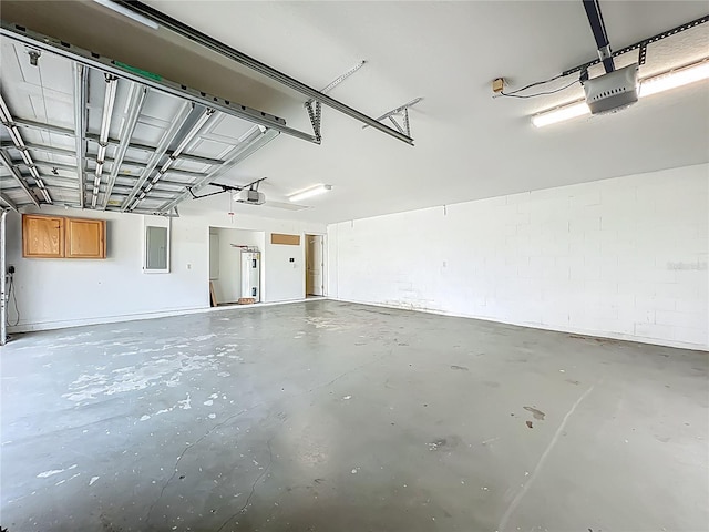 36730 Oconee Ave, Eustis, FL 32736 - garage featuring electric panel, a garage door opener, and concrete block wall