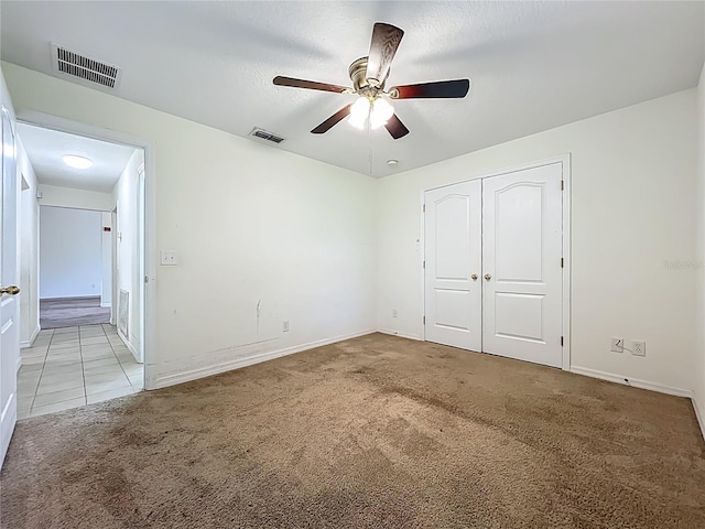 36730 Oconee Ave, Eustis, FL 32736 - unfurnished bedroom with carpet flooring, a closet, ceiling fan, and tile patterned flooring