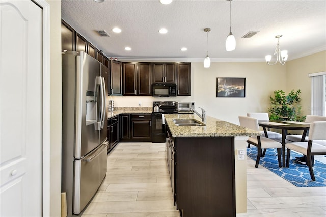 2409 Martins Run, Tavares, FL 32778 - kitchen with black appliances, ornamental molding, a center island with sink, a textured ceiling, and dark brown cabinetry