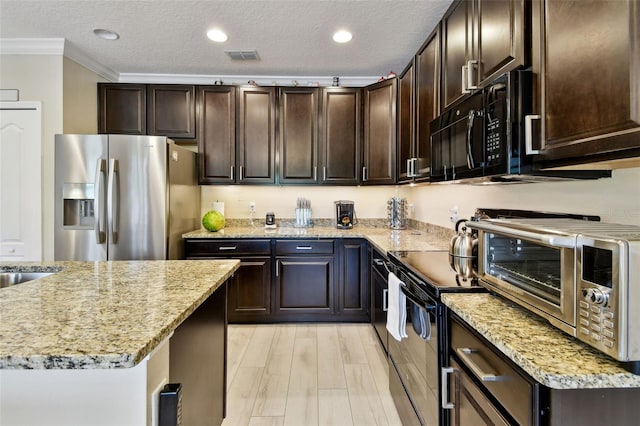 2409 Martins Run, Tavares, FL 32778 - kitchen with stainless steel fridge, black microwave, ornamental molding, light stone countertops, and dark brown cabinetry