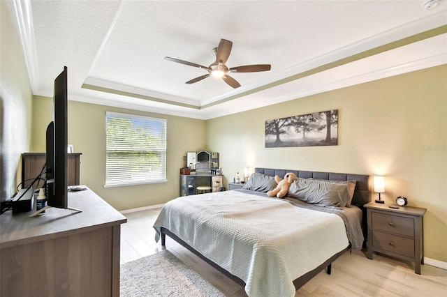 2409 Martins Run, Tavares, FL 32778 - bedroom featuring a raised ceiling, light wood-style flooring, crown molding, and a ceiling fan