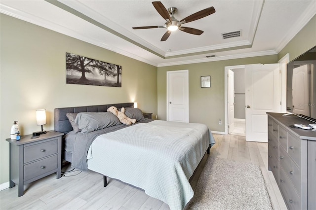 2409 Martins Run, Tavares, FL 32778 - bedroom with a raised ceiling, light wood-type flooring, crown molding, and a ceiling fan
