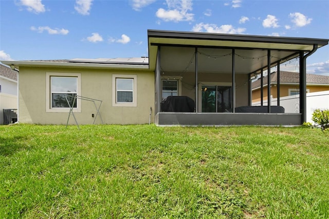 2409 Martins Run, Tavares, FL 32778 - rear view of property featuring a sunroom, stucco siding, solar panels, and a lawn