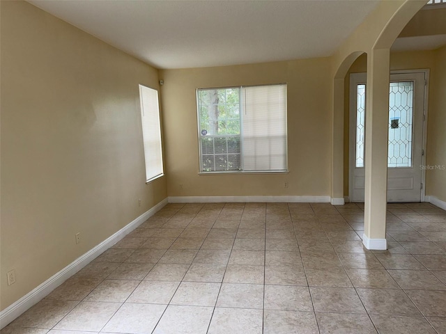 14508 Cedar Branch Way, Orlando, FL 32824 - empty room with arched walkways, light tile patterned floors, and baseboards