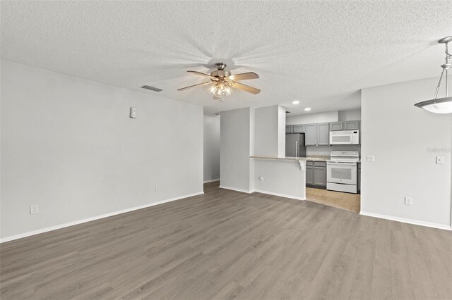 5436 E Michigan St Unit 7, Orlando, FL 32812 - unfurnished living room featuring light wood-type flooring, ceiling fan, a textured ceiling, and recessed lighting