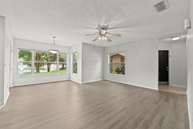 5436 E Michigan St Unit 7, Orlando, FL 32812 - unfurnished living room with wood finished floors, a ceiling fan, and a textured ceiling