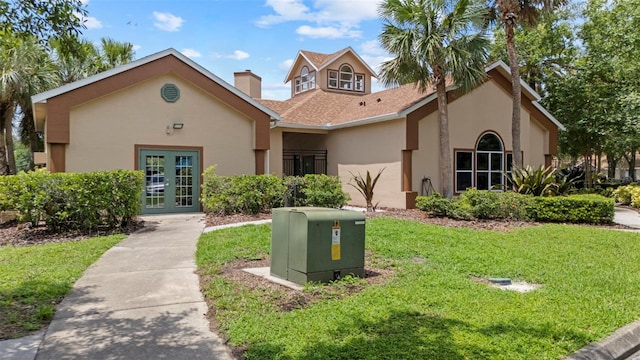 5436 E Michigan St Unit 7, Orlando, FL 32812 - view of front of property featuring french doors, stucco siding, a front lawn, and a chimney