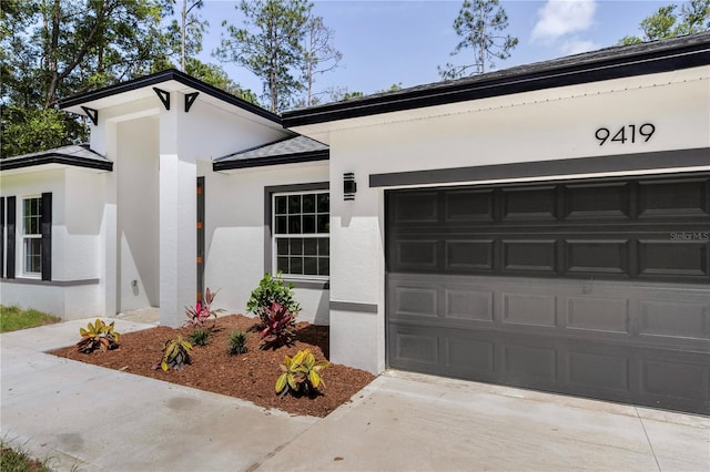 9419 N Jackson Way, Citrus Springs, FL 34434 - view of front facade featuring stucco siding, an attached garage, and concrete driveway