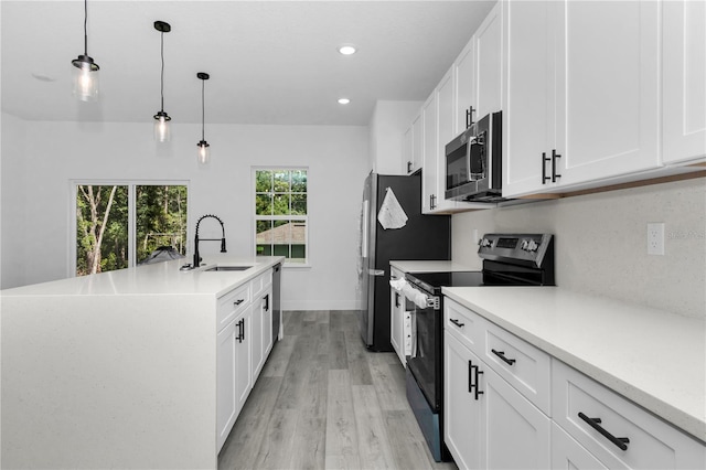 9419 N Jackson Way, Citrus Springs, FL 34434 - kitchen featuring stainless steel appliances, a sink, light countertops, a kitchen island with sink, and light wood-style flooring
