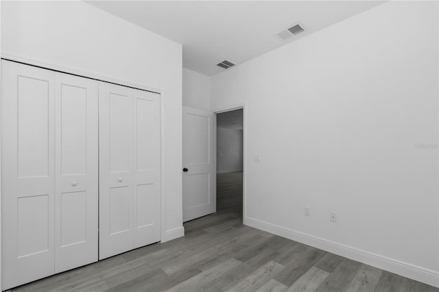 9419 N Jackson Way, Citrus Springs, FL 34434 - unfurnished bedroom featuring light wood-style floors, a closet, and baseboards