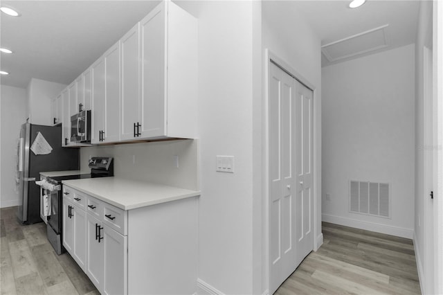 9419 N Jackson Way, Citrus Springs, FL 34434 - kitchen with stainless steel appliances, light wood-type flooring, recessed lighting, baseboards, and white cabinetry