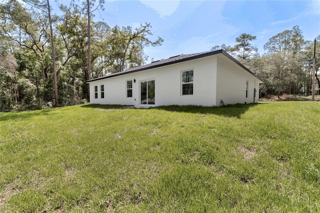 9419 N Jackson Way, Citrus Springs, FL 34434 - back of house featuring stucco siding and a yard
