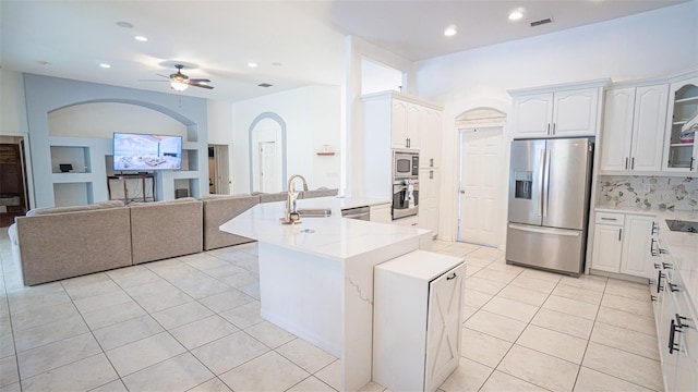 19951 Quinlan St, Orlando, FL 32833 - kitchen featuring stainless steel appliances, light tile patterned floors, ceiling fan, arched walkways, and open floor plan