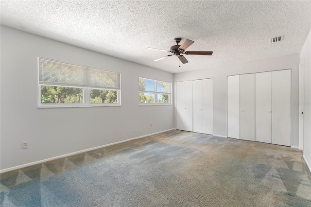818 Park Lake Cir Unit 10, Maitland, FL 32751 - unfurnished bedroom with multiple closets, a textured ceiling, carpet flooring, and a ceiling fan