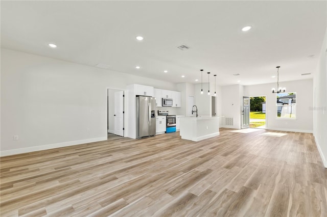 178 Marion Oaks Ln, Ocala, FL 34473 - unfurnished living room with a sink, a chandelier, baseboards, recessed lighting, and light wood-style flooring