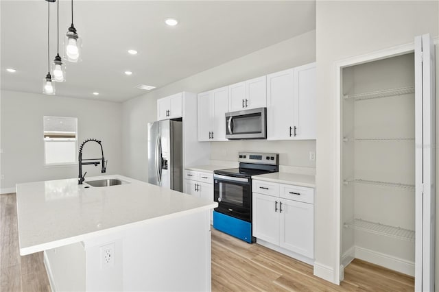 178 Marion Oaks Ln, Ocala, FL 34473 - kitchen with appliances with stainless steel finishes, a sink, light wood-style floors, white cabinetry, and recessed lighting