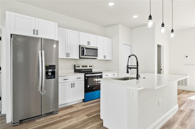 178 Marion Oaks Ln, Ocala, FL 34473 - kitchen featuring stainless steel appliances, a sink, light wood-style flooring, an island with sink, and white cabinets