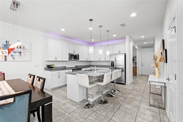 11054 Hanlon Terrace Aly, Winter Garden, FL 34787 - kitchen featuring appliances with stainless steel finishes, white cabinets, a breakfast bar area, and recessed lighting