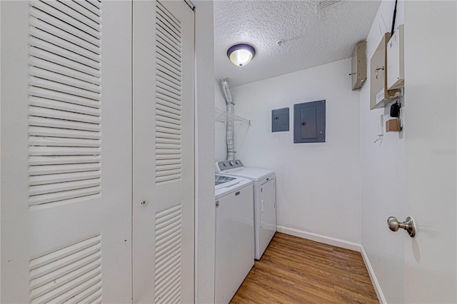5500 Metrowest Blvd Unit 203, Orlando, FL 32811 - laundry room featuring separate washer and dryer, electric panel, light wood finished floors, a textured ceiling, and baseboards