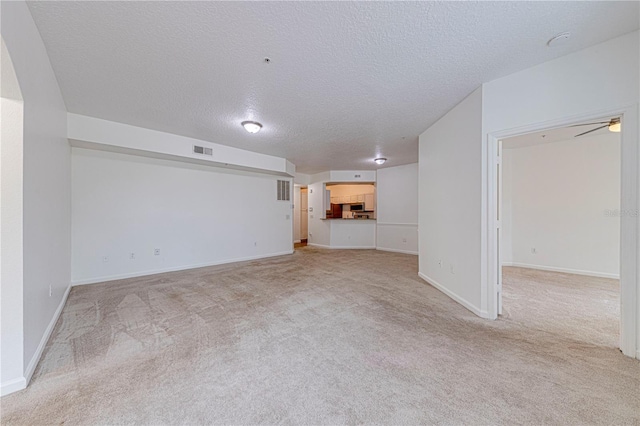 5500 Metrowest Blvd Unit 203, Orlando, FL 32811 - unfurnished living room with a textured ceiling, light carpet, baseboards, and ceiling fan