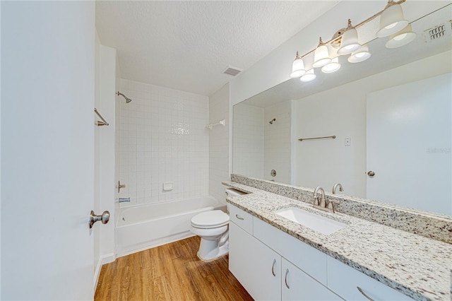 5500 Metrowest Blvd Unit 203, Orlando, FL 32811 - bathroom with wood finished floors, vanity, toilet, tub / shower combination, and a textured ceiling