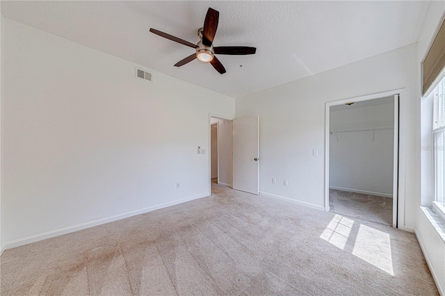 5500 Metrowest Blvd Unit 203, Orlando, FL 32811 - unfurnished bedroom featuring light colored carpet, a ceiling fan, a closet, baseboards, and a walk in closet