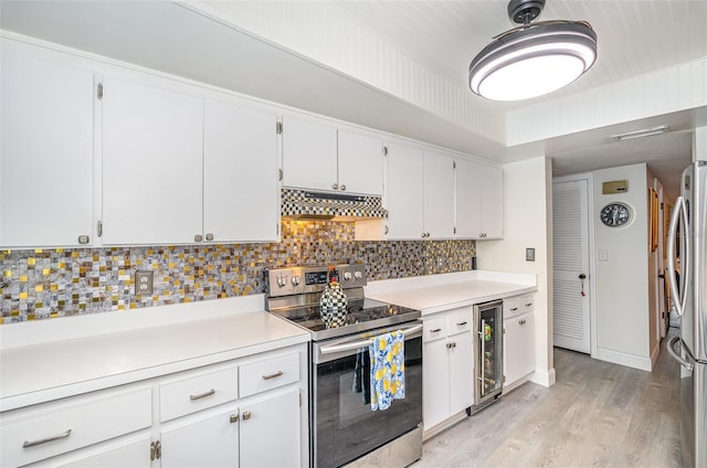 4850 Ocean Beach Blvd Unit 208, Cocoa Beach, FL 32931 - kitchen featuring stainless steel appliances, wine cooler, under cabinet range hood, and light countertops