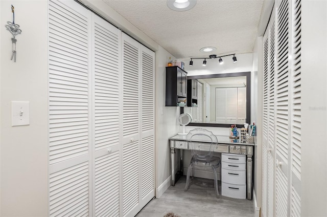4850 Ocean Beach Blvd Unit 208, Cocoa Beach, FL 32931 - corridor with a textured ceiling, light wood finished floors, and baseboards