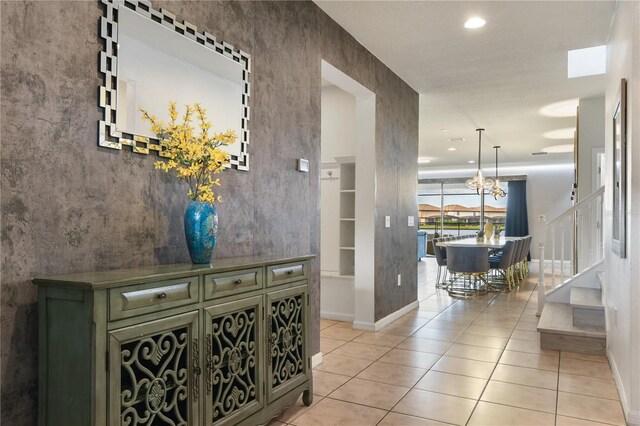 8801 Macapa Dr, Kissimmee, FL 34747 - corridor featuring stairway, a chandelier, light tile patterned floors, baseboards, and recessed lighting