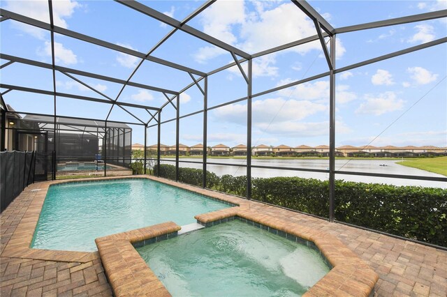 8801 Macapa Dr, Kissimmee, FL 34747 - view of swimming pool with a water view, a pool with connected hot tub, a residential view, and a lanai