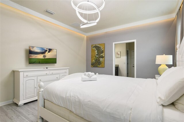 8801 Macapa Dr, Kissimmee, FL 34747 - bedroom featuring ensuite bath, baseboards, a chandelier, and light wood-style floors