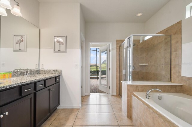 8801 Macapa Dr, Kissimmee, FL 34747 - bathroom with vanity, a shower stall, a garden tub, and tile patterned flooring
