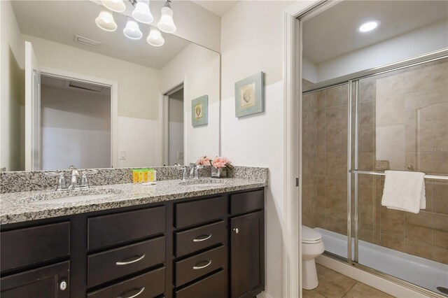 8801 Macapa Dr, Kissimmee, FL 34747 - bathroom featuring double vanity, tile patterned floors, toilet, and a shower stall