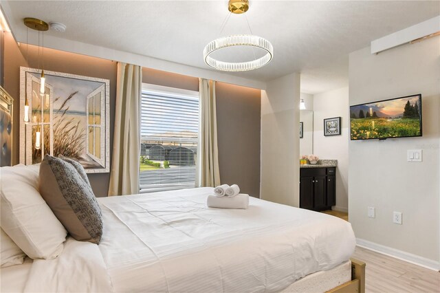 8801 Macapa Dr, Kissimmee, FL 34747 - bedroom featuring light wood finished floors, baseboards, and connected bathroom