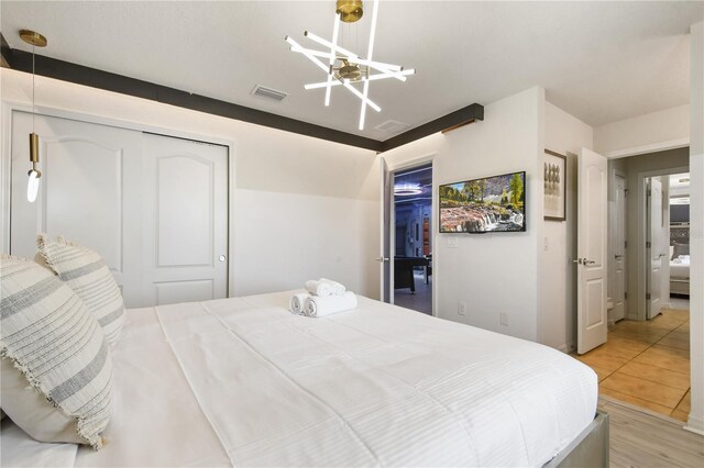8801 Macapa Dr, Kissimmee, FL 34747 - bedroom with a chandelier, a closet, light wood-style floors, and ceiling fan