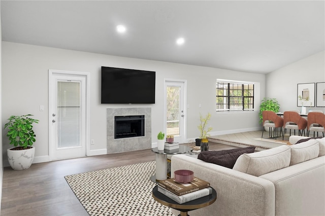 104 Bryant Ct, Sebastian, FL 32958 - living area featuring wood finished floors, baseboards, a tile fireplace, lofted ceiling, and recessed lighting