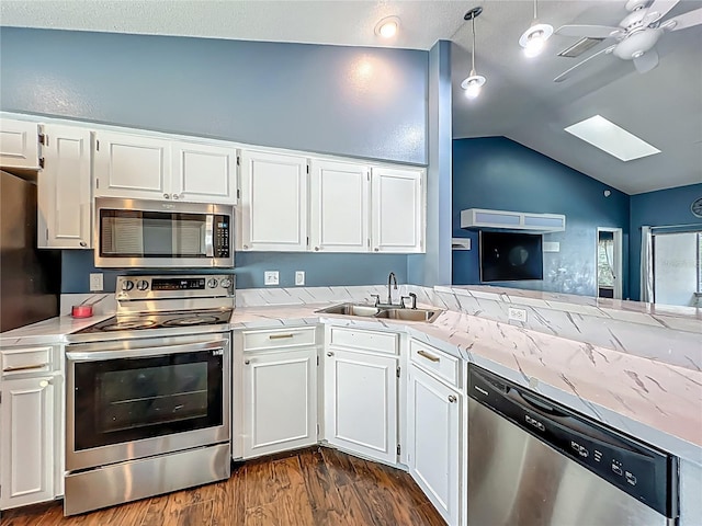 4942 Eden View Ct, Orlando, FL 32810 - kitchen featuring stainless steel appliances, a sink, a skylight, dark wood-style floors, and lofted ceiling