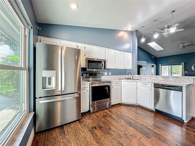 4942 Eden View Ct, Orlando, FL 32810 - kitchen with appliances with stainless steel finishes, a ceiling fan, vaulted ceiling, a peninsula, and white cabinetry