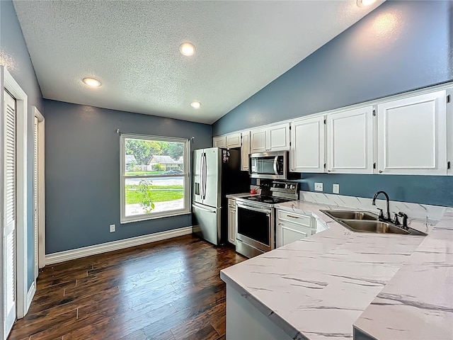 4942 Eden View Ct, Orlando, FL 32810 - kitchen with appliances with stainless steel finishes, a sink, a textured ceiling, white cabinetry, and lofted ceiling