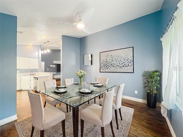 4942 Eden View Ct, Orlando, FL 32810 - dining room featuring dark wood-style flooring, a ceiling fan, and baseboards