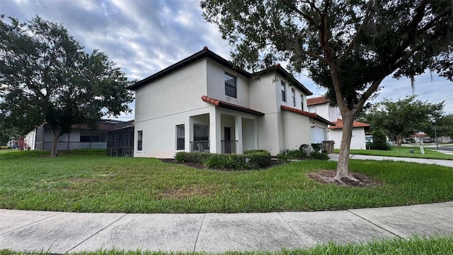 16631 Lazy Breeze Loop, Clermont, FL 34714 - view of side of home with a lawn, stucco siding, a garage, and glass enclosure