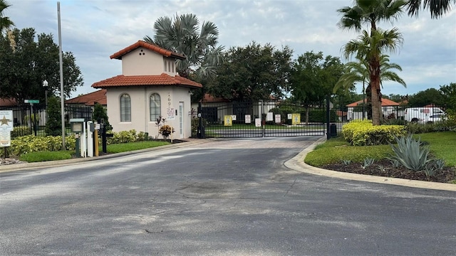 16631 Lazy Breeze Loop, Clermont, FL 34714 - view of asphalt road with a gate, a gated entry, and curbs