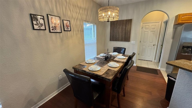 16631 Lazy Breeze Loop, Clermont, FL 34714 - dining room with light wood-type flooring, a chandelier, baseboards, a textured wall, and arched walkways