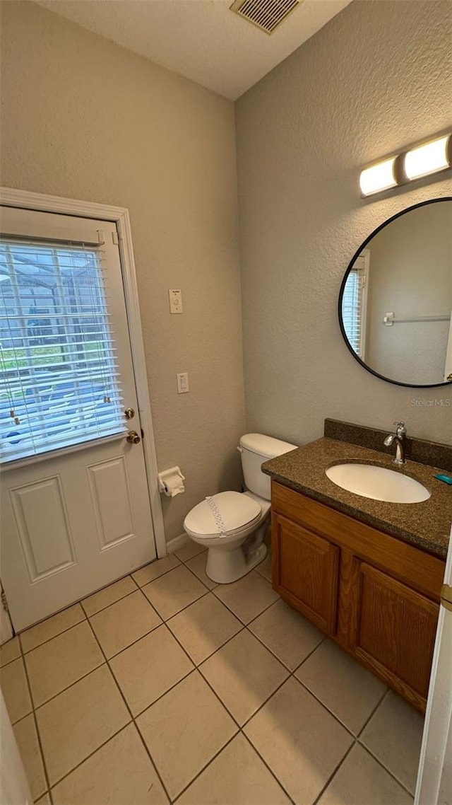 16631 Lazy Breeze Loop, Clermont, FL 34714 - bathroom featuring vanity, tile patterned floors, toilet, and a textured wall
