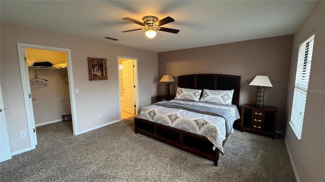 16631 Lazy Breeze Loop, Clermont, FL 34714 - carpeted bedroom with a walk in closet, a closet, baseboards, and a ceiling fan