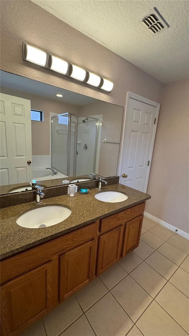 16631 Lazy Breeze Loop, Clermont, FL 34714 - full bath with a textured ceiling, double vanity, tile patterned flooring, a shower stall, and a bath