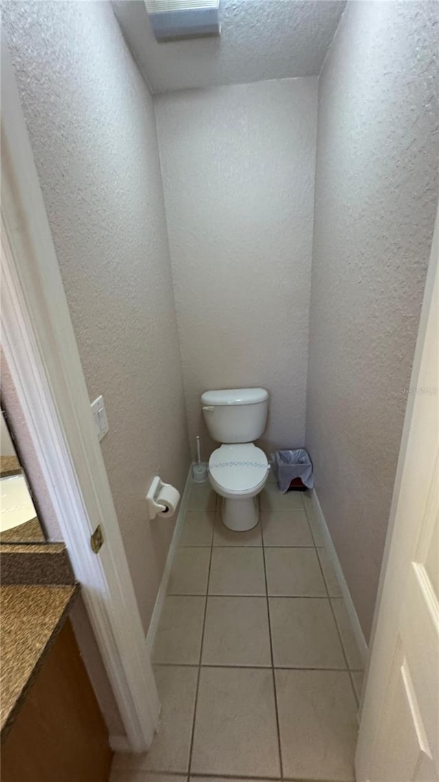 16631 Lazy Breeze Loop, Clermont, FL 34714 - bathroom with toilet, tile patterned flooring, vanity, baseboards, and a textured ceiling
