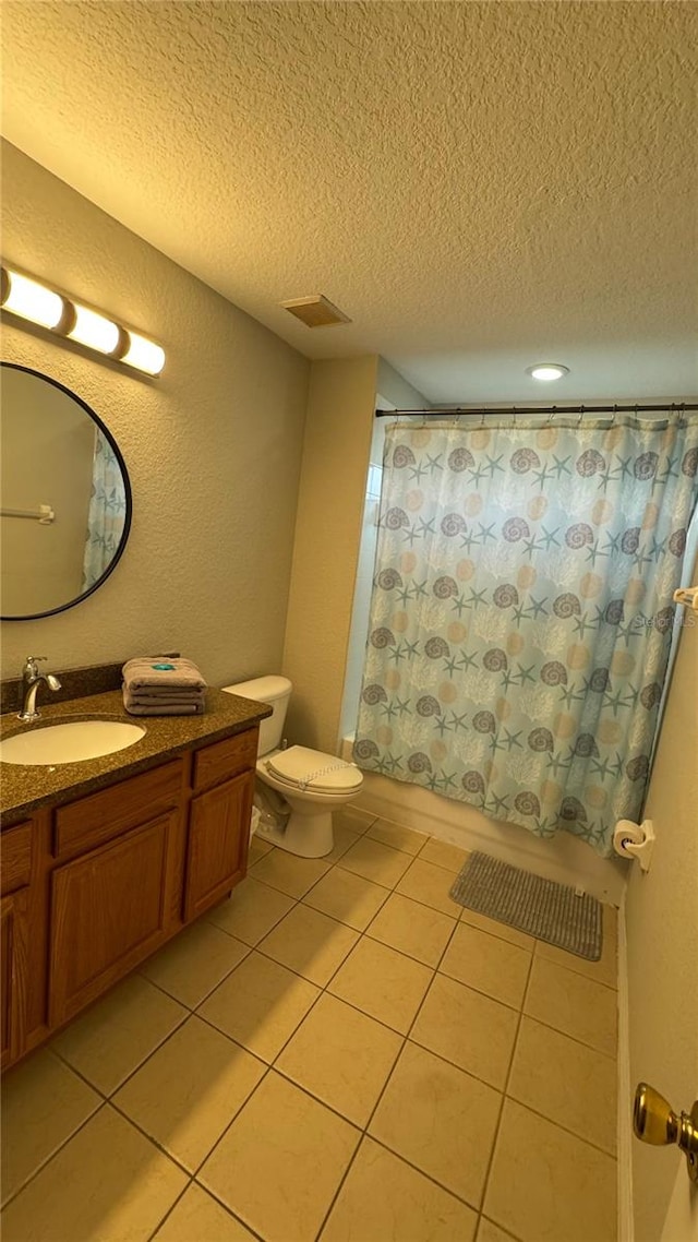 16631 Lazy Breeze Loop, Clermont, FL 34714 - bathroom featuring a textured ceiling, tile patterned flooring, vanity, toilet, and a textured wall
