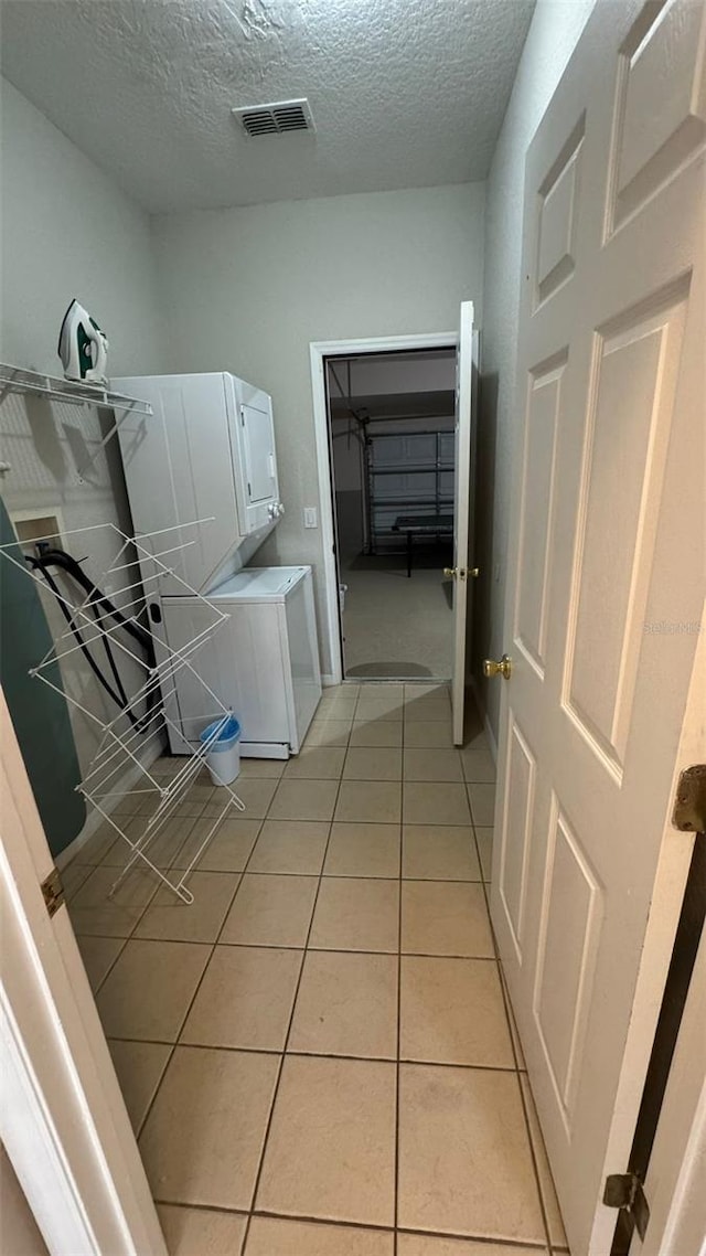 16631 Lazy Breeze Loop, Clermont, FL 34714 - laundry room featuring a textured ceiling, light tile patterned floors, and hookup for a washing machine