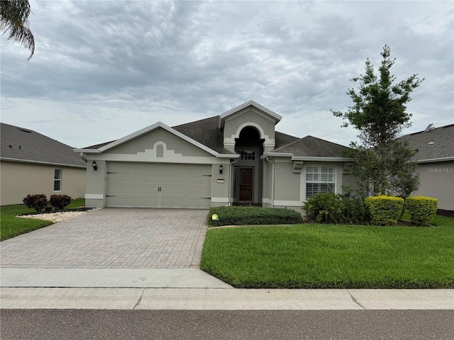 541 Arena Dr, Davenport, FL 33837 - single story home with stucco siding, decorative driveway, a garage, and a front lawn